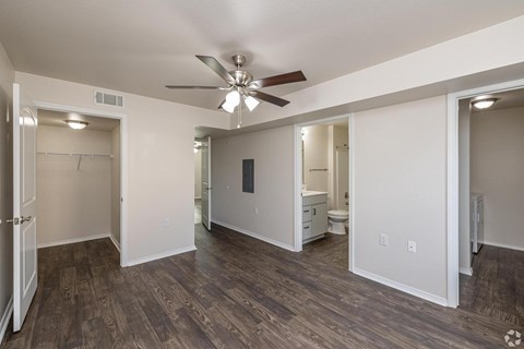 A room with a ceiling fan and wooden flooring.