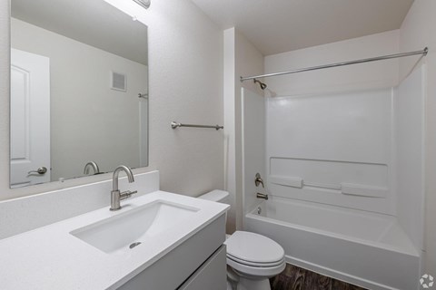 A white bathroom with a toilet, sink, and bathtub.