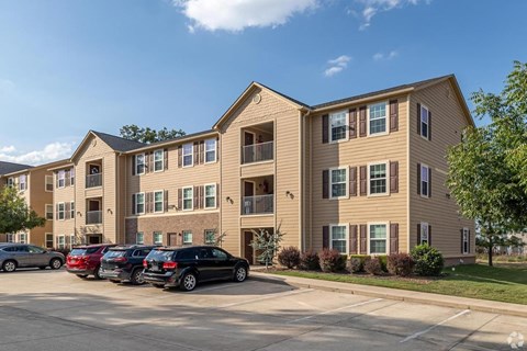Apartment building with cars parked in front.