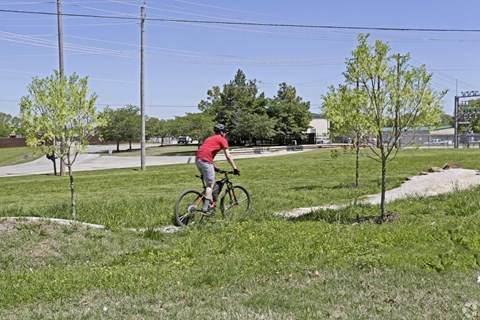 A man riding a bicycle in a grassy area.