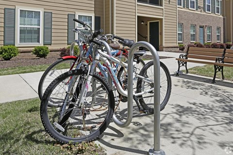A bicycle is locked to a bike rack on a sidewalk.