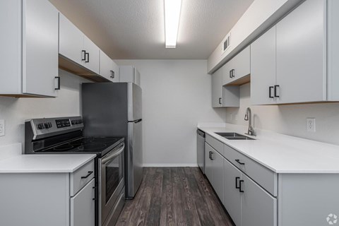 A kitchen with white cabinets and a stainless steel refrigerator.