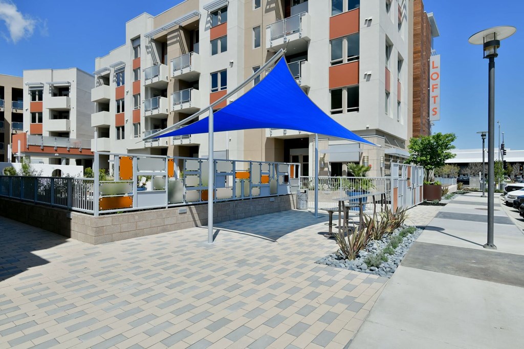 a blue tent is set up in front of Main Street Lofts Cupertino