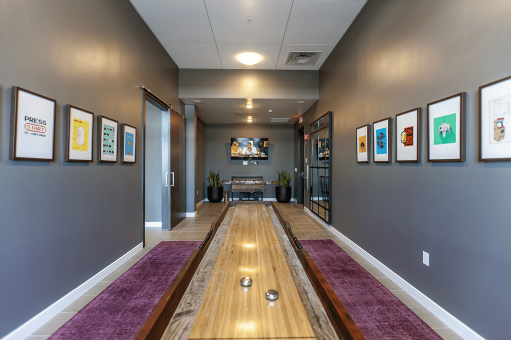 hallway with purple rugs and framed pictures on the wall inside Main Street Lofts Cupertino
