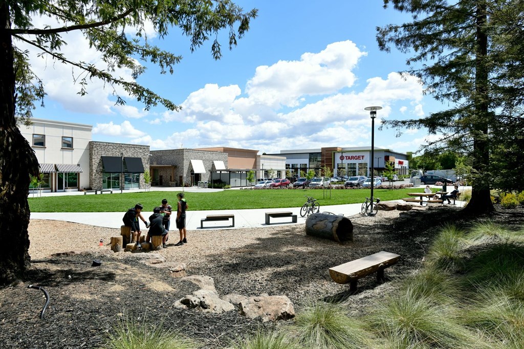 a group of people standing in front of a building outside Main Street Lofts Cupertino