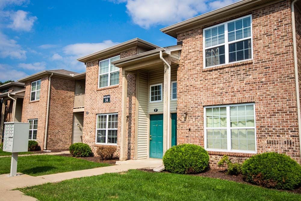 Brick apartment building with a green door at Maple Tree Apartments in LaPorte, IN