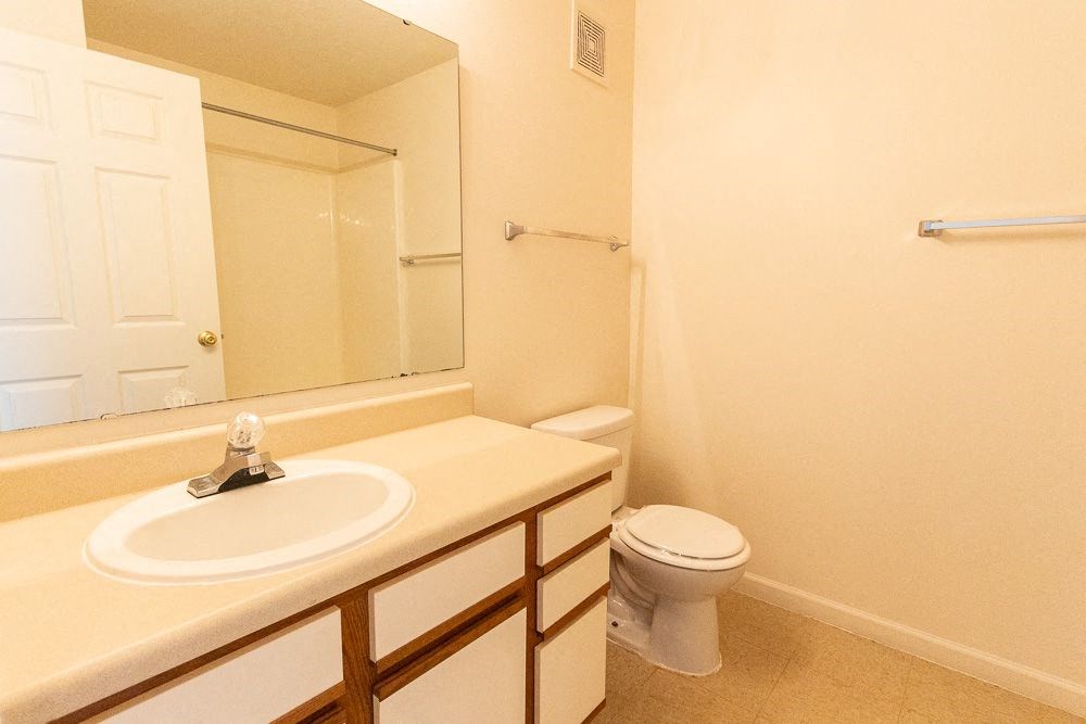 Bathroom with a sink toilet and mirror at Maple Tree Apartments in LaPorte, IN