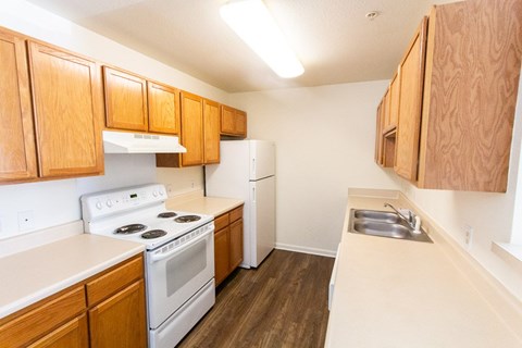 A kitchen with wooden cabinets and white appliances.