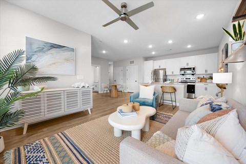 A living room with a white couch and a painting on the wall.