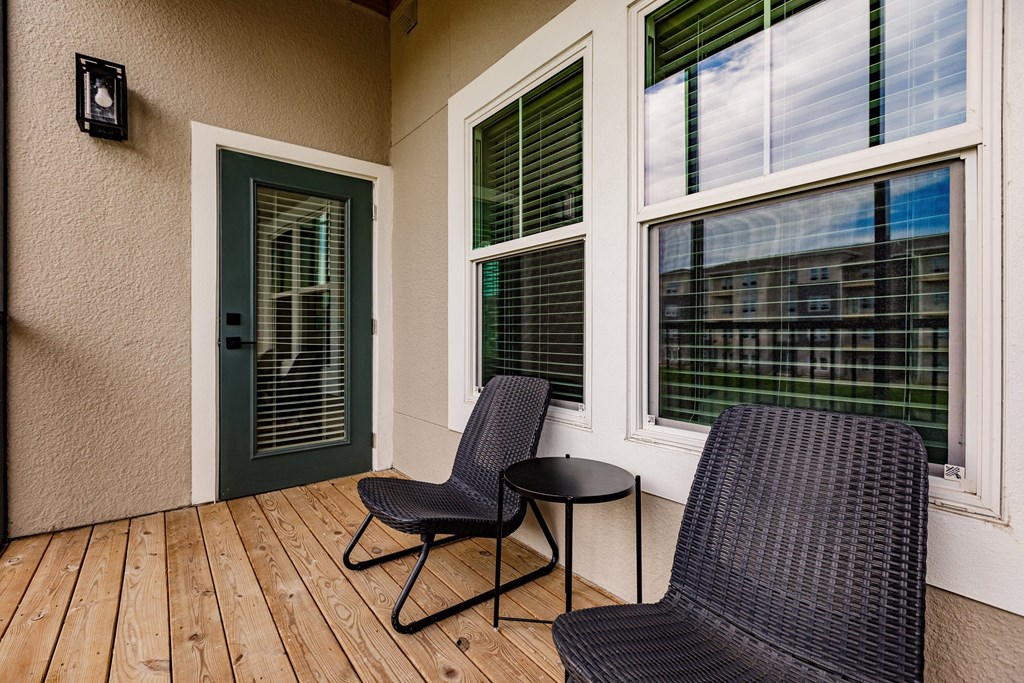 a balcony with chairs and a table