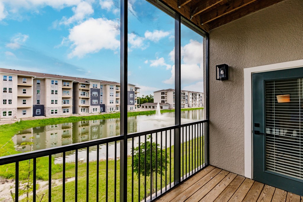 a balcony with a view of a pond and Vantage apartment buildings