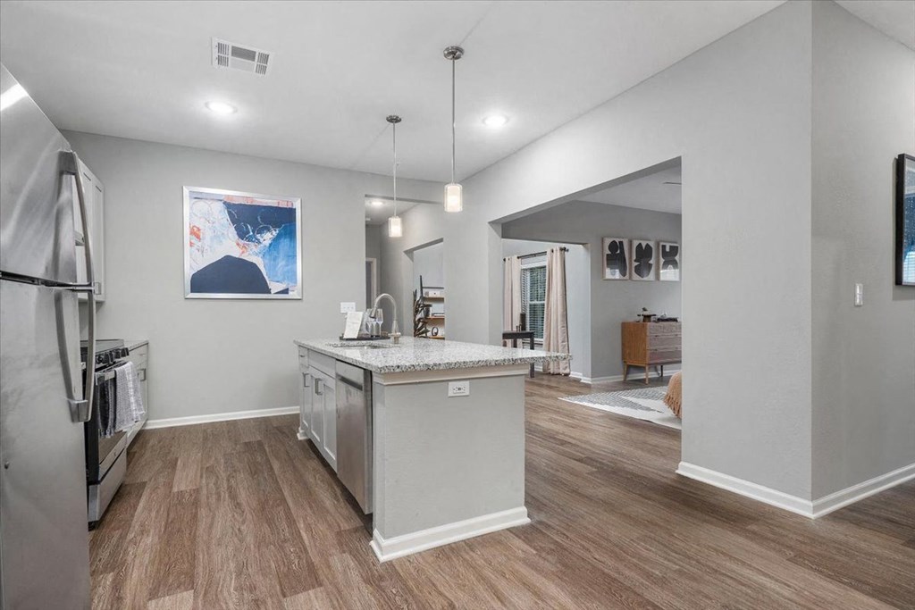 the kitchen with an island and living room  at Aurora Luxury Apartments in Madison AL