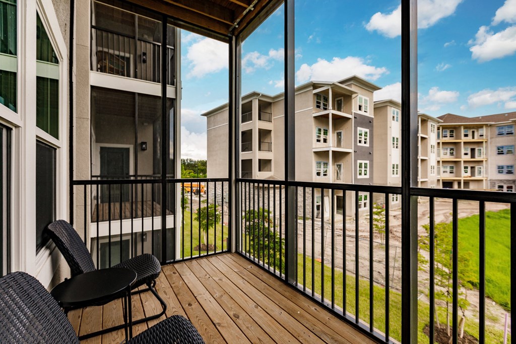 a screened in balcony with a wood floor