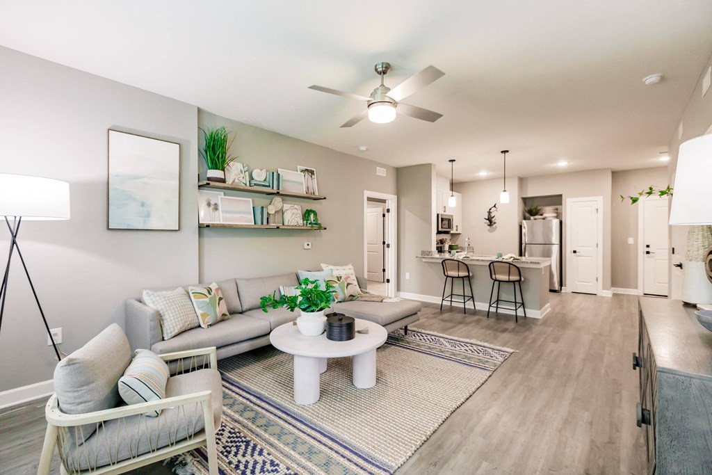 an open living room and kitchen with a ceiling fan