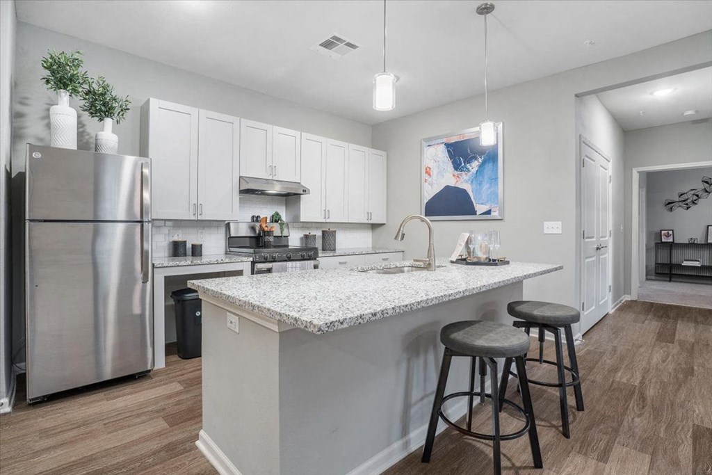 a kitchen with a counter top and a stainless steel refrigerator