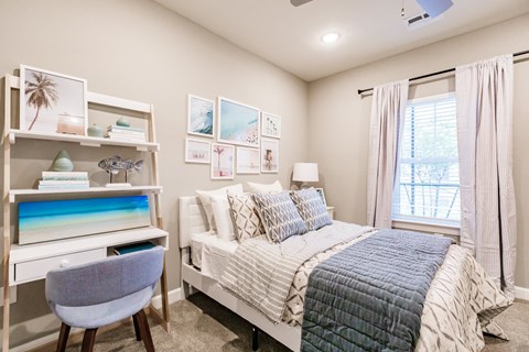 a bedroom with a bed and a desk and a window at Vantage Luxury Apartments in Cape Coral, Fl