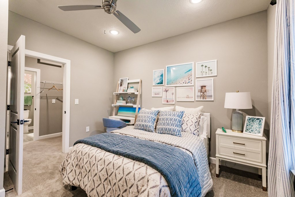 a bedroom with a bed and a ceiling fan