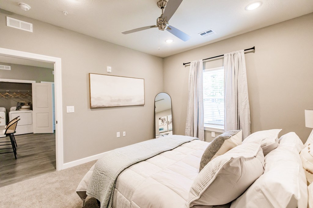 a bedroom with a large bed and a ceiling fan