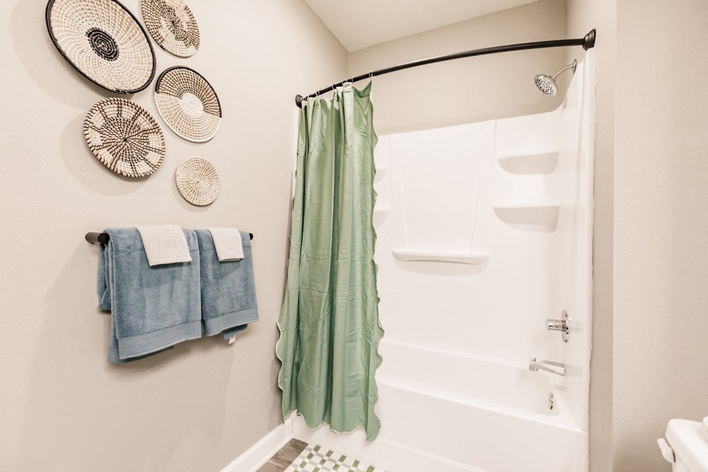 a bathroom with a shower and towels and a sink