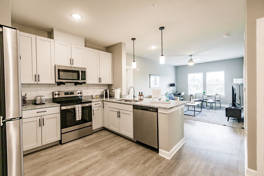 a kitchen with stainless steel appliances and white cabinets at Vantage Luxury Apartments in  Cape Coral, FL