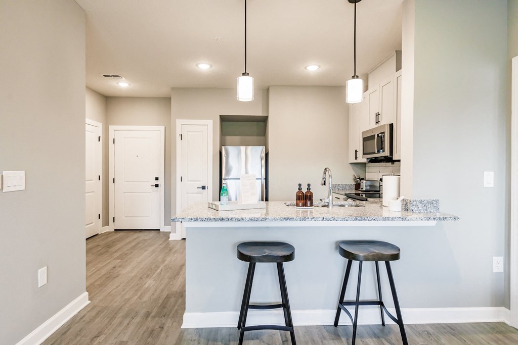 bar stools at a kitchen bar with a refrigerator in the background
