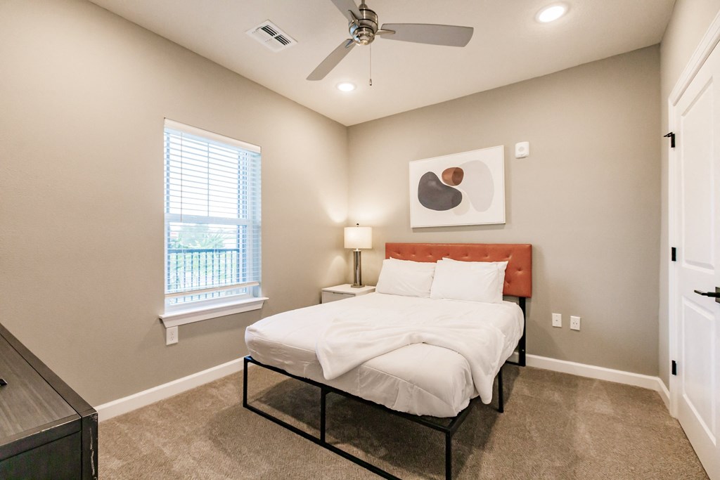 a bedroom with a bed and night stand at Vantage Luxury Apartments in  Cape Coral, FL