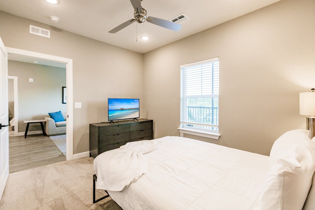 a bedroom with a bed, tv, and dresser at Vantage apartments in cape coral