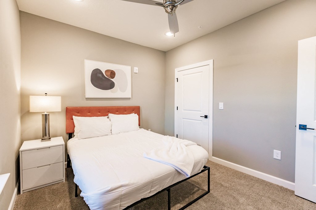 a bedroom with a white bed and a closet