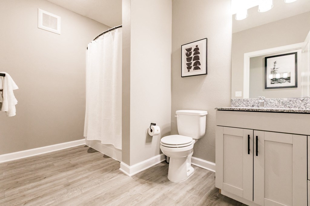 a bathroom with a toilet and a shower and a sink