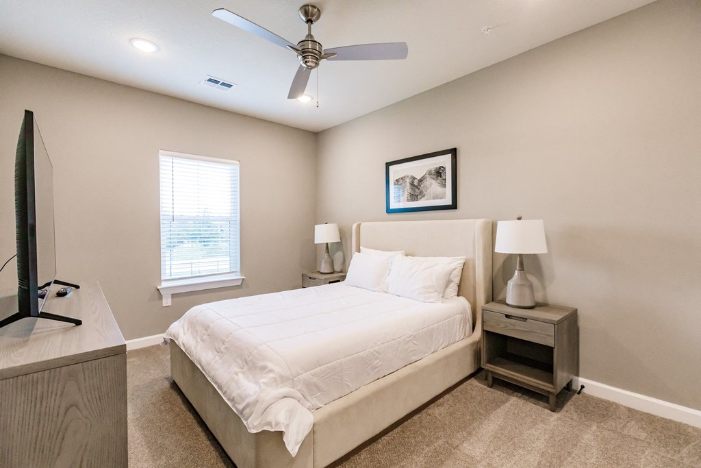 a bedroom with a bed and a ceiling fan