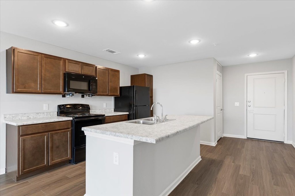 A kitchen with brown cabinets and a white island.