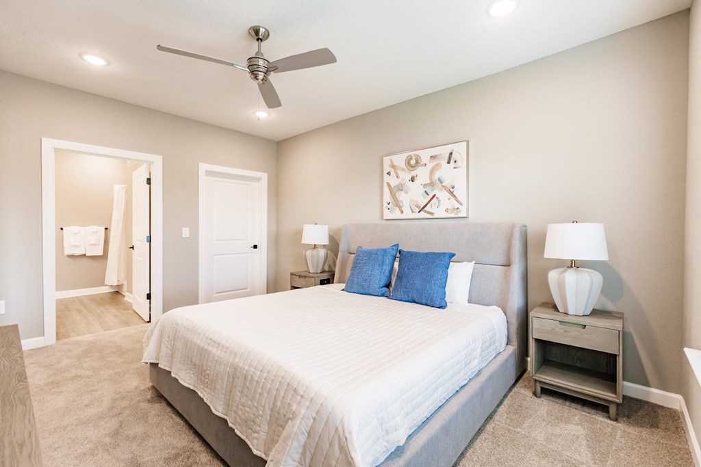 a bedroom with a bed, a night stand, and a bathroom