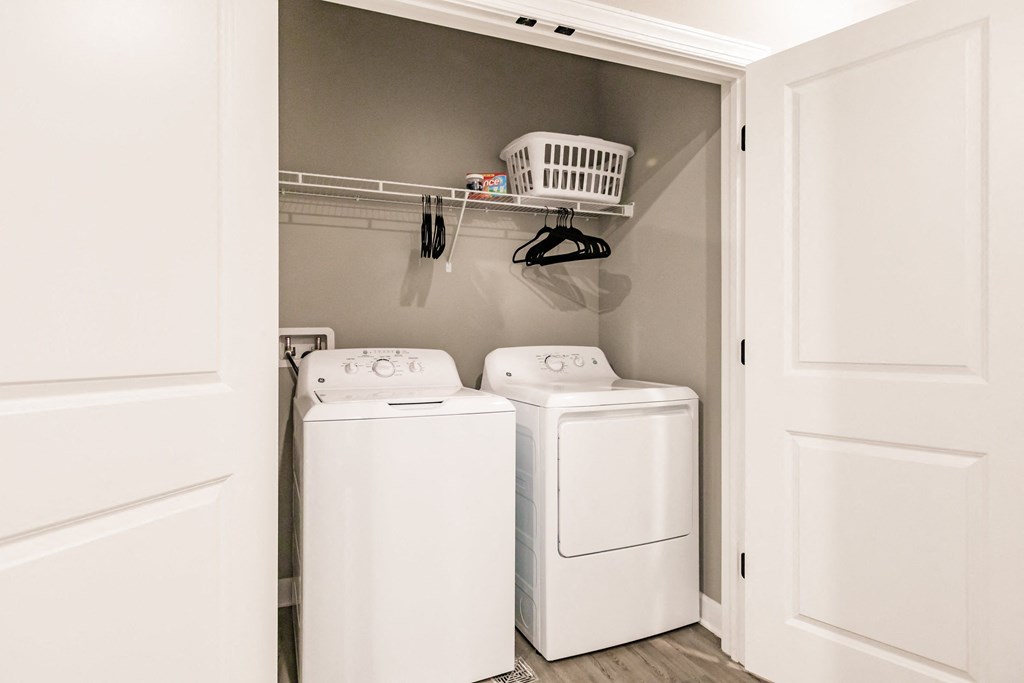 a washer and dryer in a laundry room with white cabinets