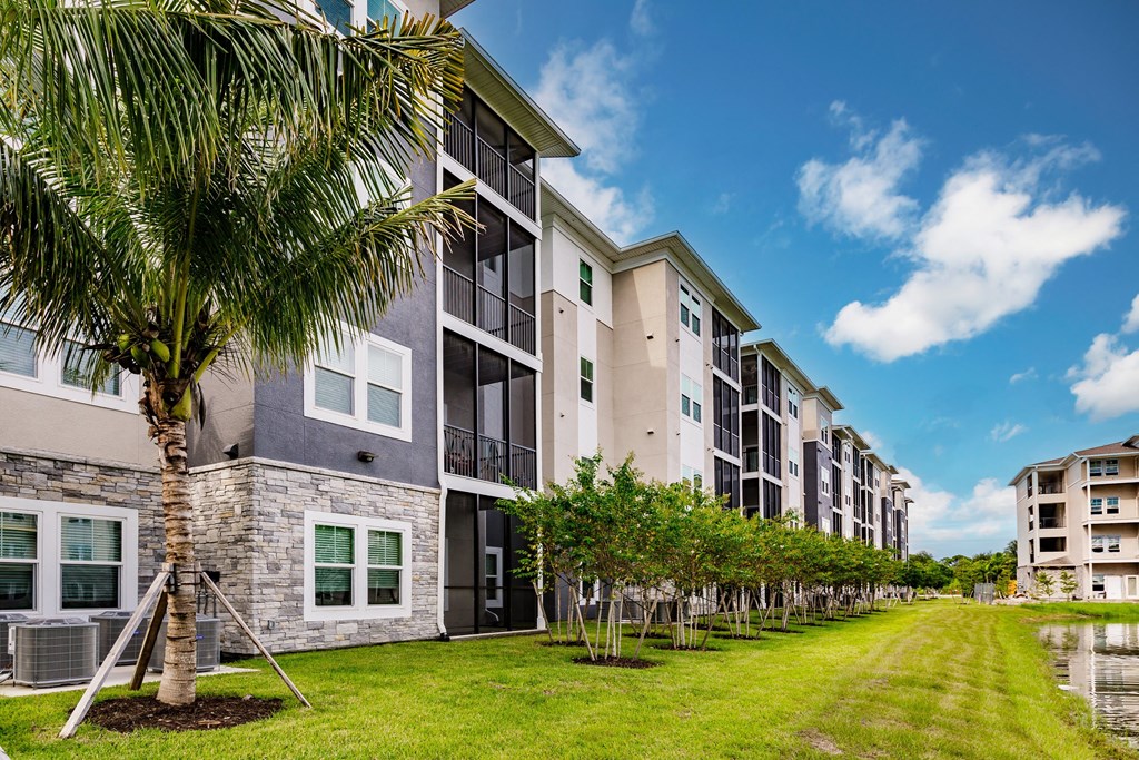 an apartment building with palm trees in front of it