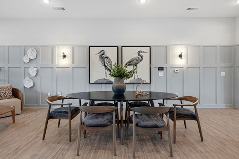 A dining room with a round table and chairs.