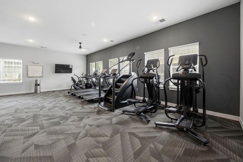 A gym with treadmills and elliptical machines.