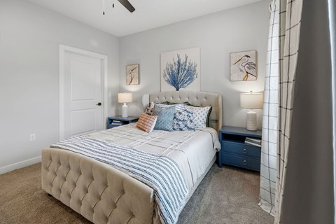 A bedroom with a large bed and two lamps.