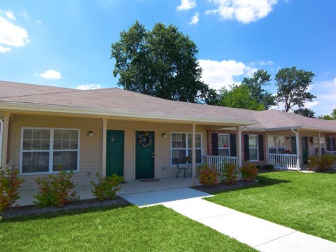 A small building with a green door and a wreath on it.