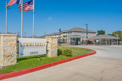 The entrance to Summerdale Apartments is marked by a large sign and flags.