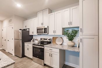 a kitchen with white cabinets and stainless steel appliances