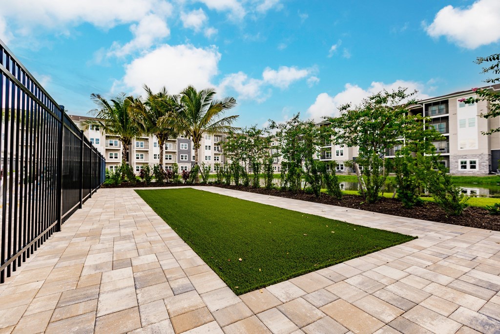 a courtyard with grass and trees in front of Vantage apartment buildings