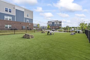 A grassy dog park with a fence at spire luxury apartments charlotte