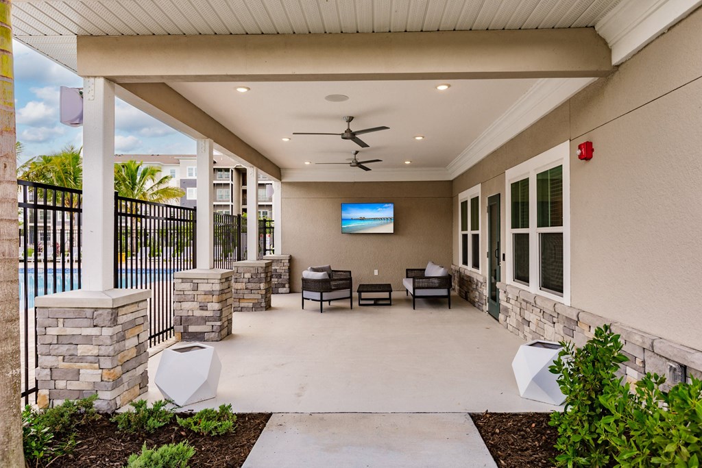 patio area with chairs, a table, and a tv at Vantage Luxury Apartments in  Cape Coral, FL