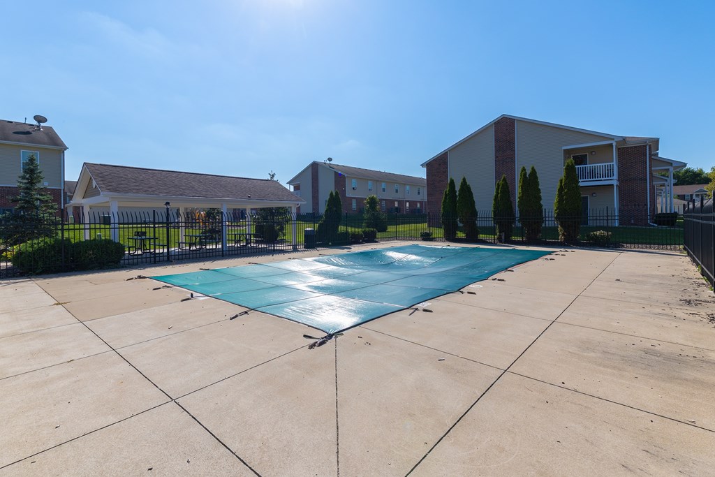 A swimming pool in a backyard surrounded by a fence.