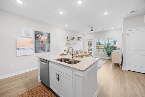 A kitchen with a white countertop and a sink.