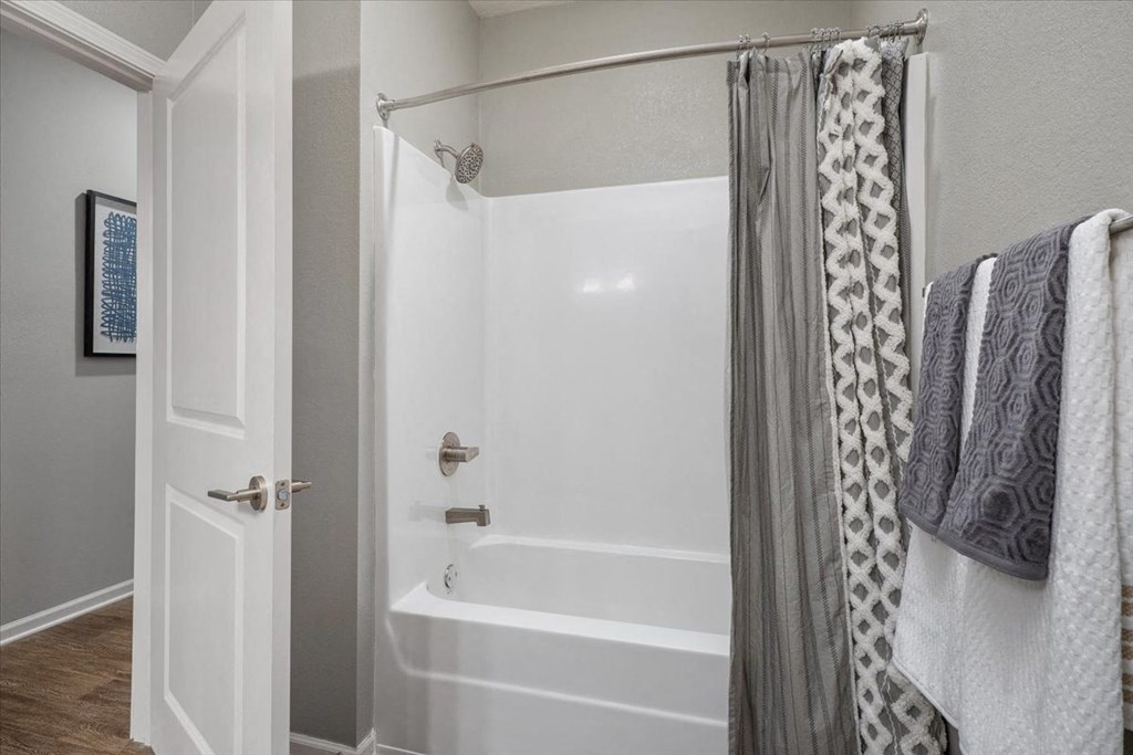 a bathroom with a tub and a shower with a curtain