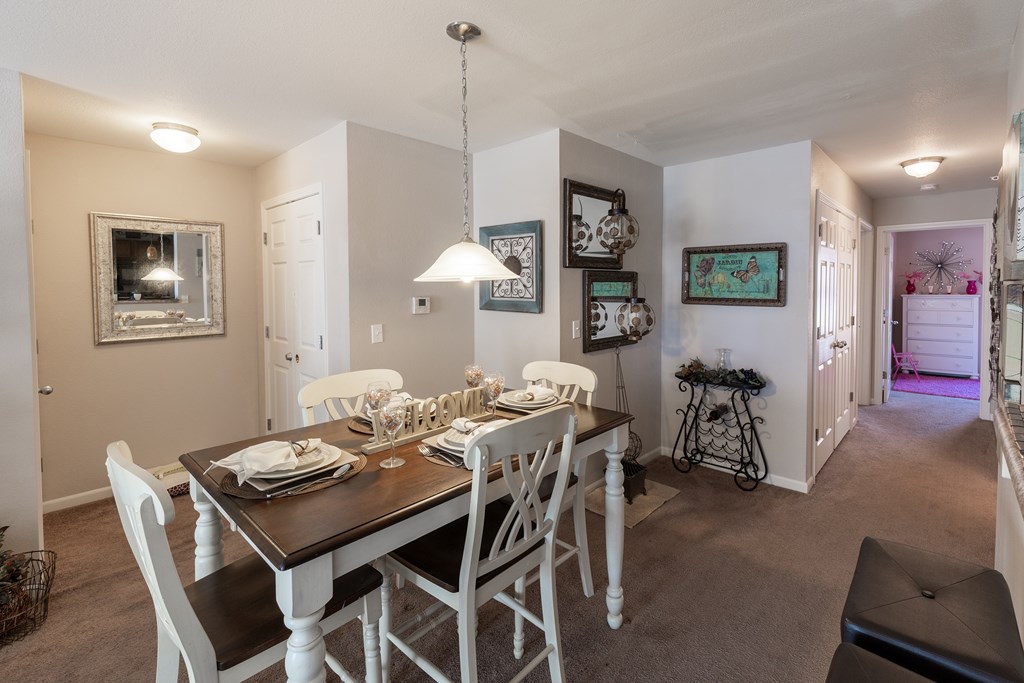 A dining room with a table set for four.