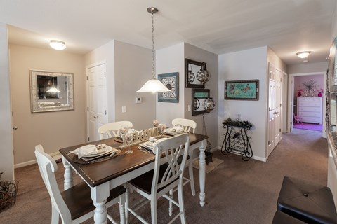 A dining room with a table set for four.