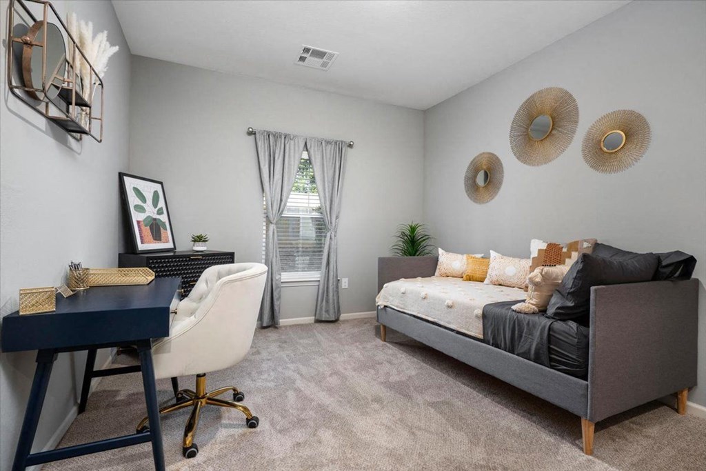 a bedroom with a couch and a desk