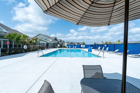 A pool with chairs and an umbrella